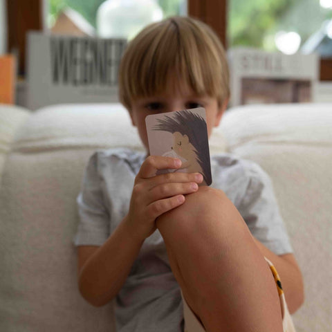 Boy holding a card from the kids' game in front of his face